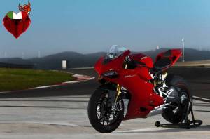 Обои красный мотоцикл Ducati на подставке возле трека на рабочий стол