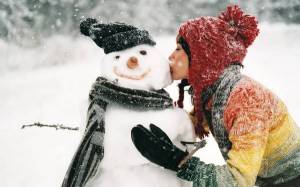 Обои девушка целует снеговика зимой на снегу на рабочий стол