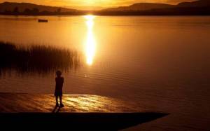 Обои ребенок возле озера на закате солнца на рабочий стол