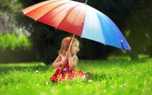 Обои ребенок сидит на траве под разноцветным зонтиком на рабочий стол
