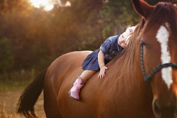 девочка, ребенок лежит верхом на лошади обои для рабочего стола