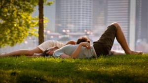 Обои парень с девушкой лежат на траве в городском парке на рабочий стол