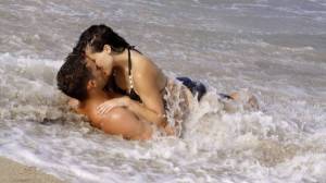 Обои парень с девушкой целуются лежа на берегу в воде на рабочий стол