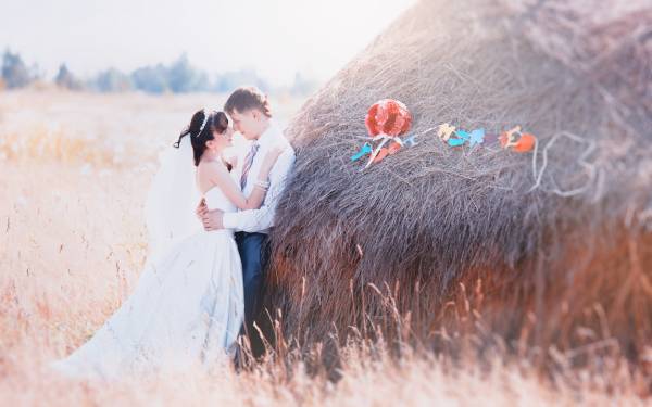 жених обнимает невесту в поле возле стога сена обои для рабочего стола