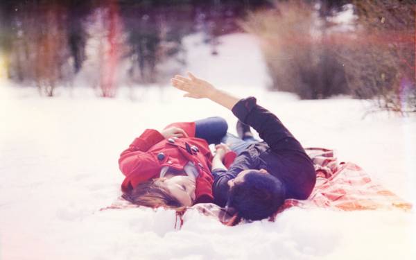 парень с девушкой держатся за руки лежа на снегу обои для рабочего стола