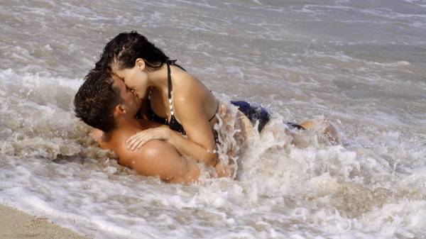 парень с девушкой целуются лежа на берегу в воде обои для рабочего стола