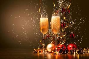 Обои новогодняя елка возле шаров и бокалов шампанского на рабочий стол